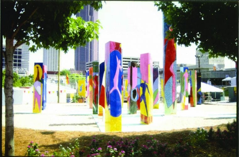 Stone pillars painted various colors in park surrounded by trees
