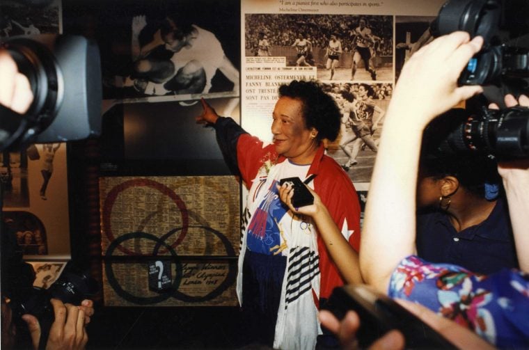 Olympian Alice Coachman points to a photograph of herself in The Olympic Woman exhibition, Alumni Hall, Georgia State University | Unidentified photographer, Atlanta, circa June 1996 | Georgia Amateur Athletic Foundation Collection, Kenan Research Center at Atlanta History Center