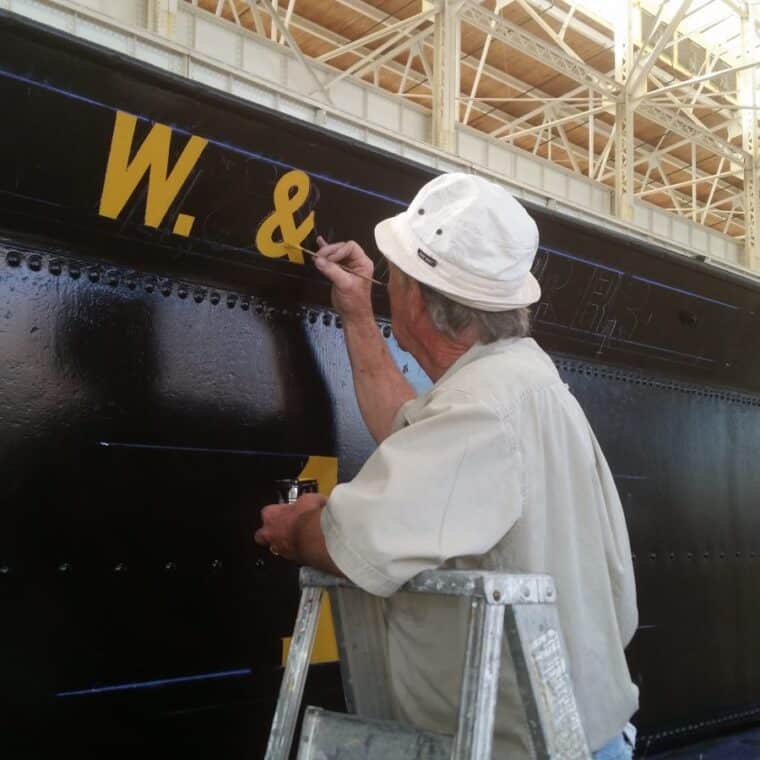 man paints the locomotive