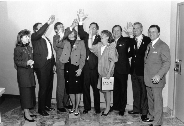 group of professionals posing with hands in air