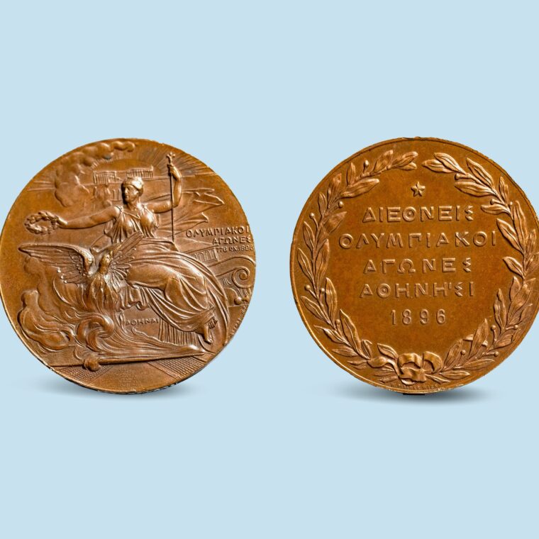 Two bronze coins with a character on side and wreath and writing on the opposite