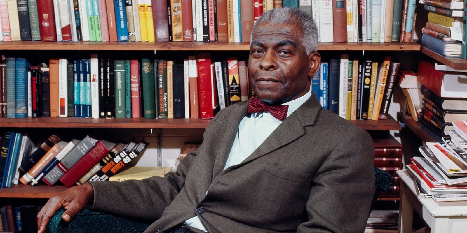 Portrait on Black man sitting in front of books