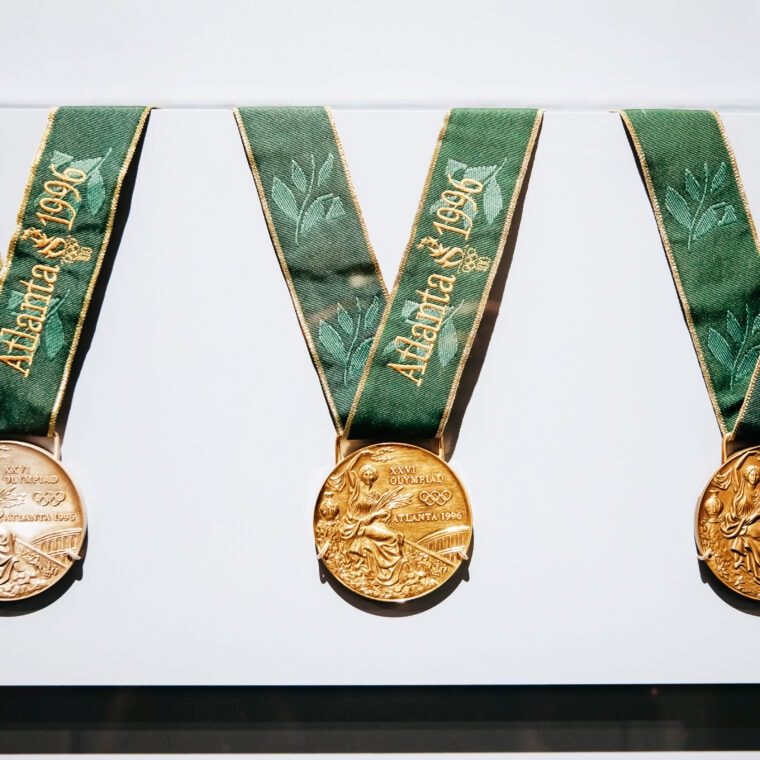 Three bronze medals with green and gold lanyards