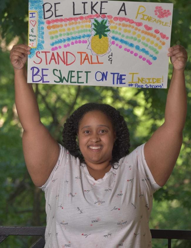 girl holding decorated sign