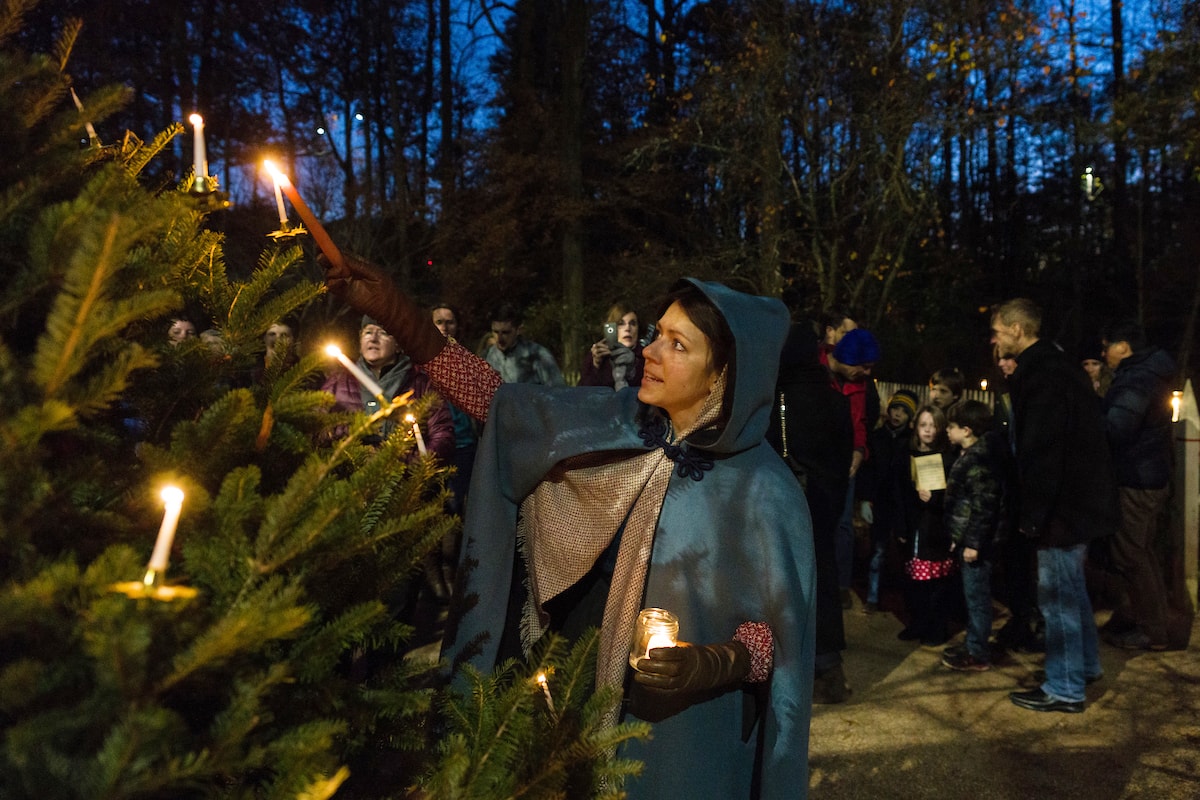 woman lighting candles on tree at Tree lighting