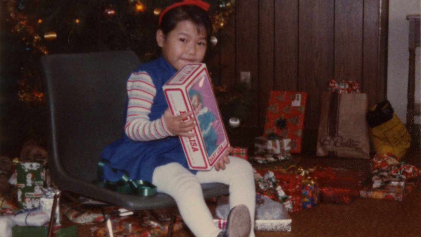 young refugee girl opening a Christmas present