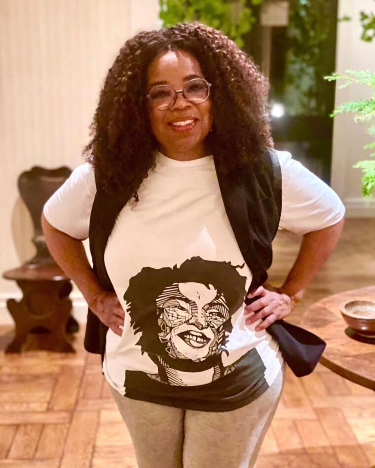 Oprah wearing a t-shirt featuring a woodcut print of Stacey Abrams by Jasmine Nicole Williams