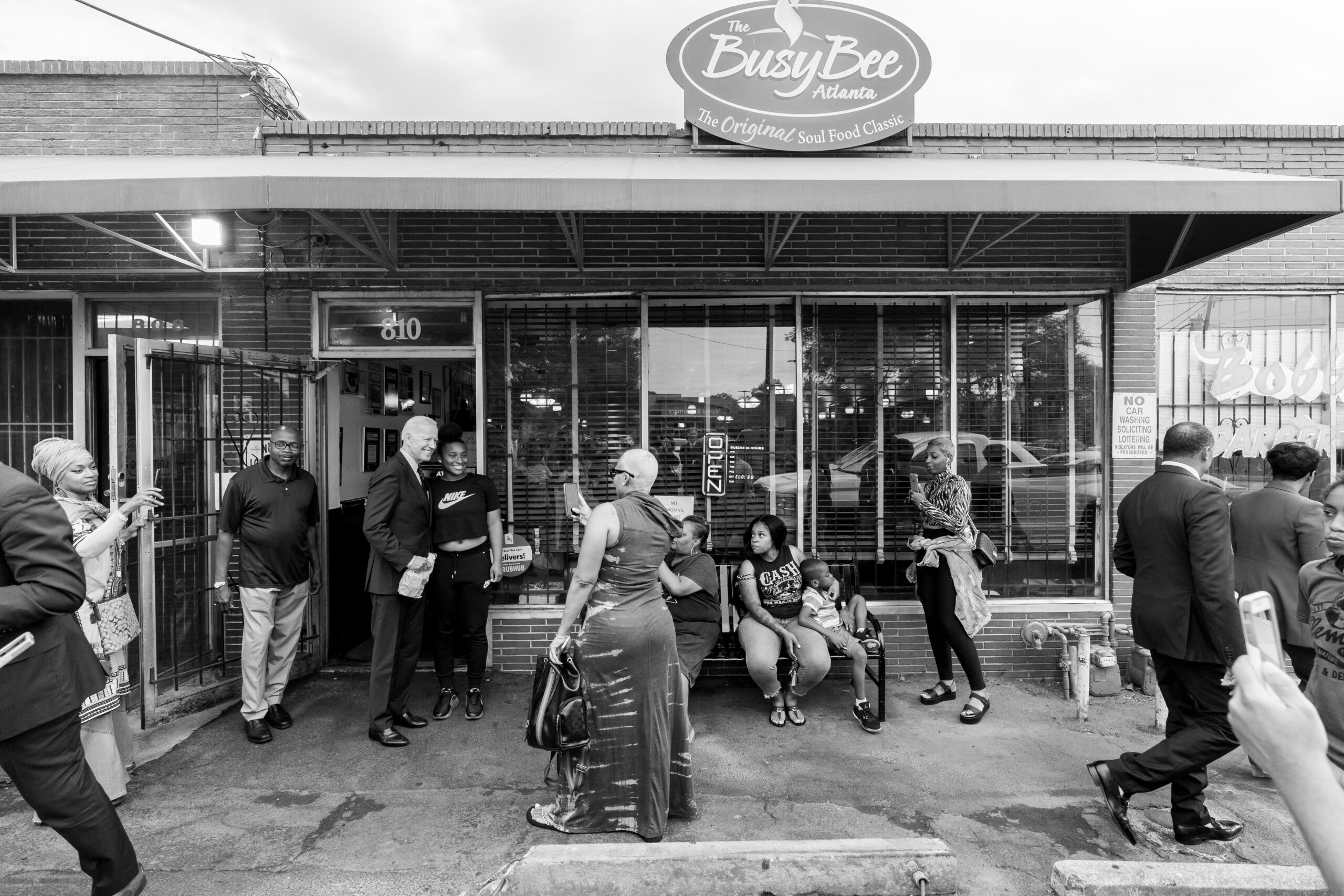 President Joe Biden poses with patrons outside of the Busy Bee Café