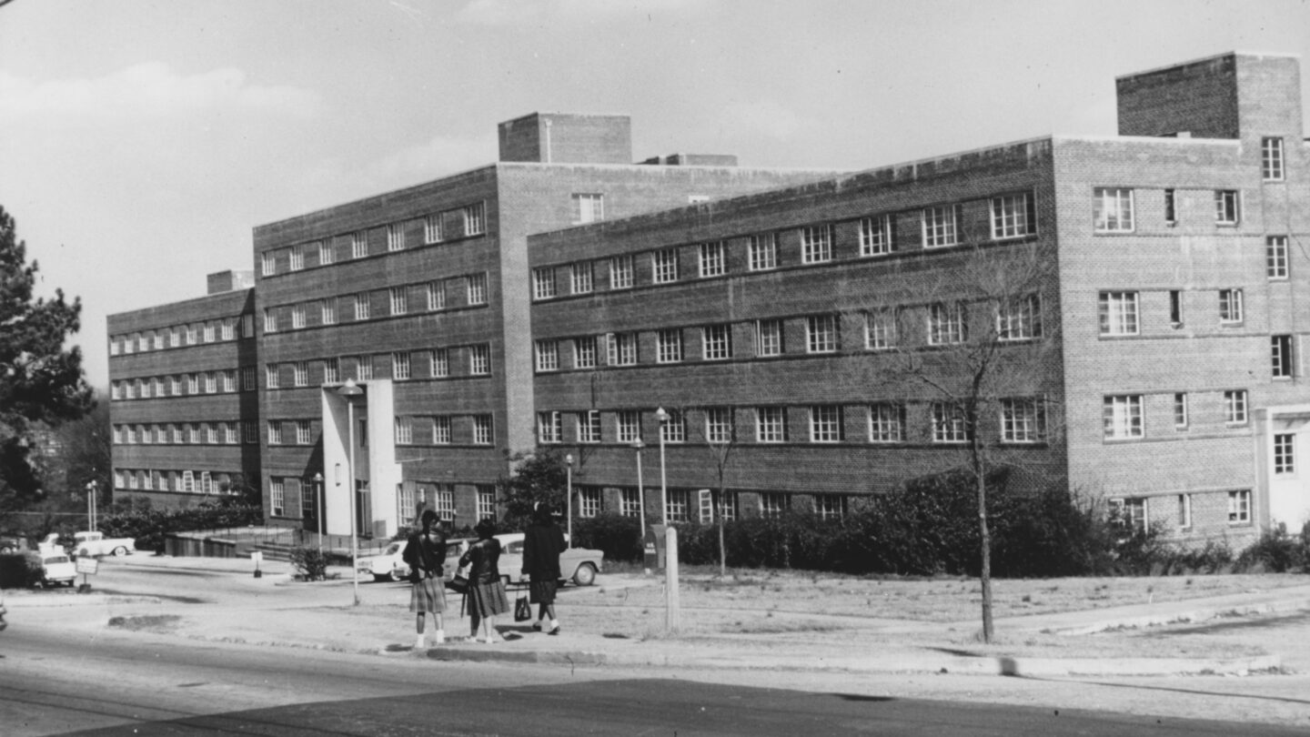 An unidentified woman interviews Walter Aiken at the Waluhaje Waluhaje Hotel Apartments.