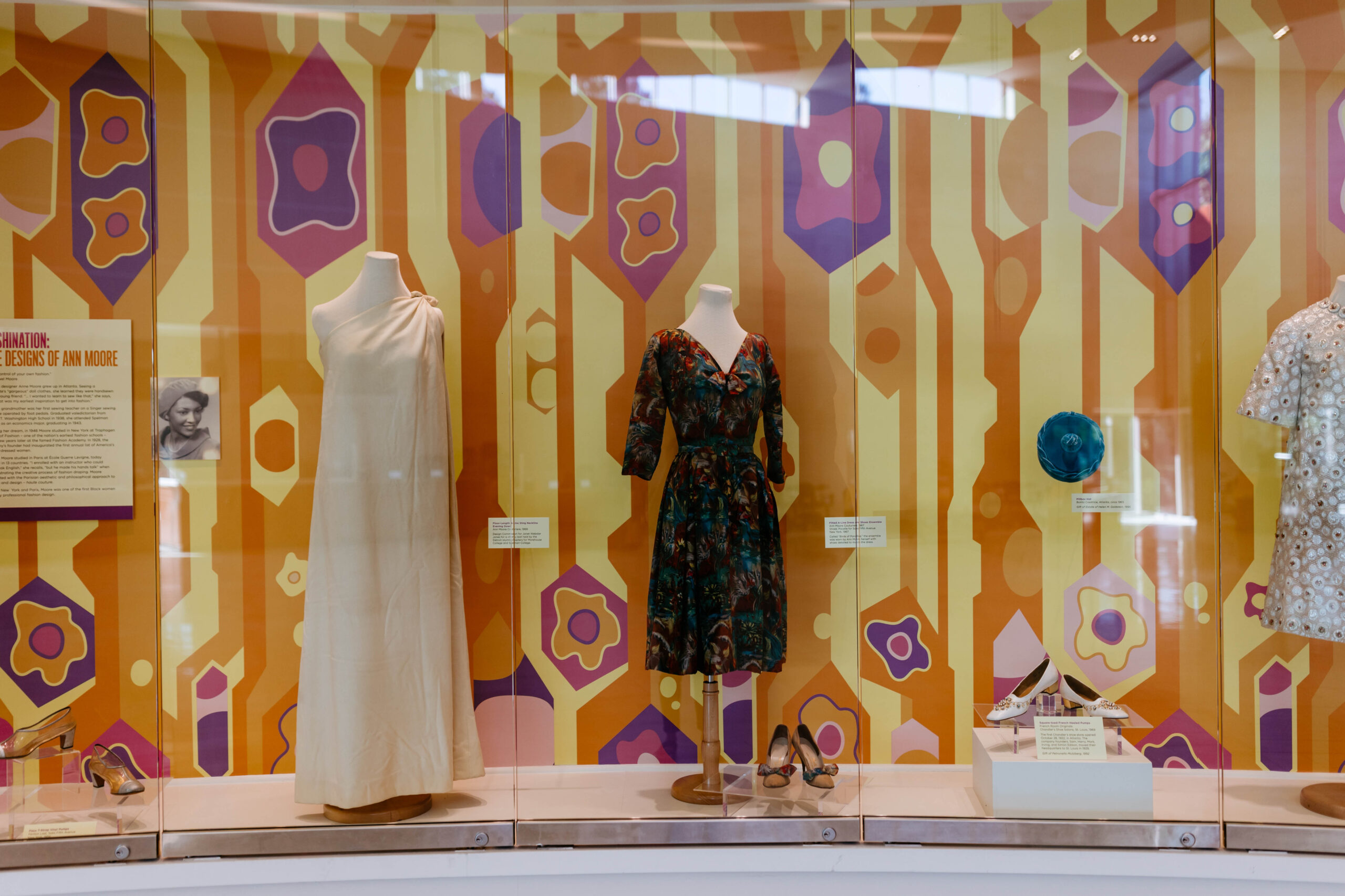 two dresses designed by Ann Moore in glass displays