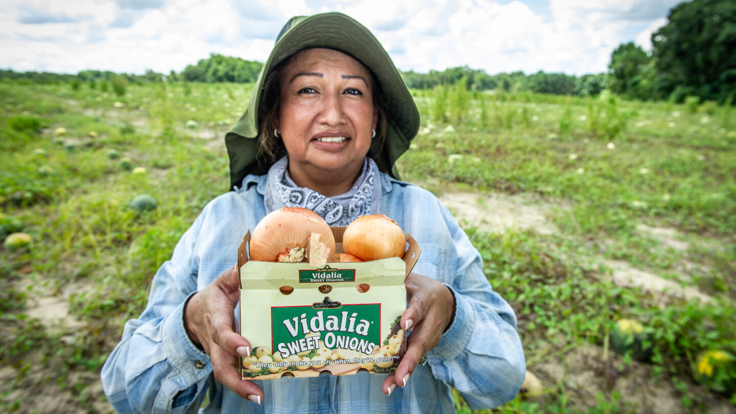 Maria Fajardo shows off produce that she is typically responsible for cultivating