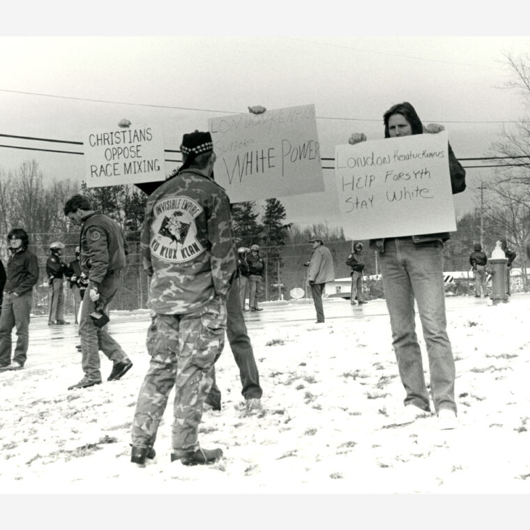 Counter-protestors hold signs at the Brotherhood March