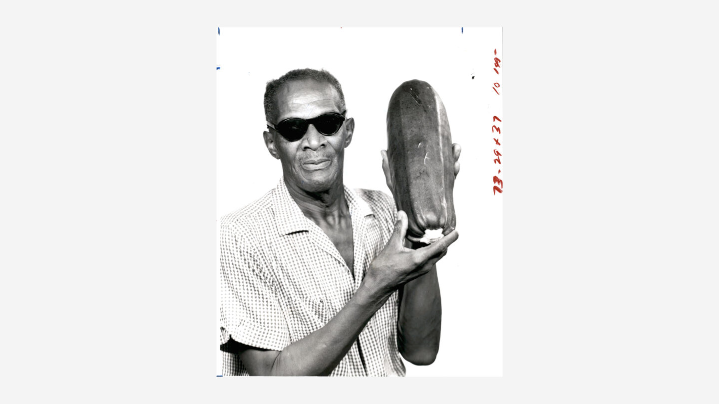 Man holding large zucchini, possibly a press photo, circa 1980s