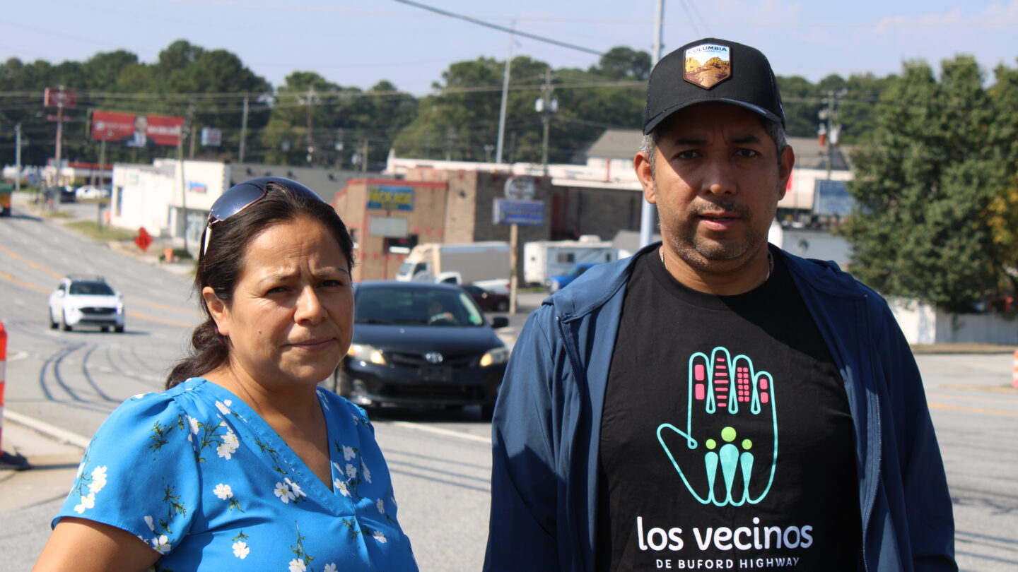 Aceli Zeneli, Director of Housing for Los Vecinos de Buford Highway and Manuel Varcenas, a volunteer with the organization, stand outside of a strip mall on Buford Highway.
