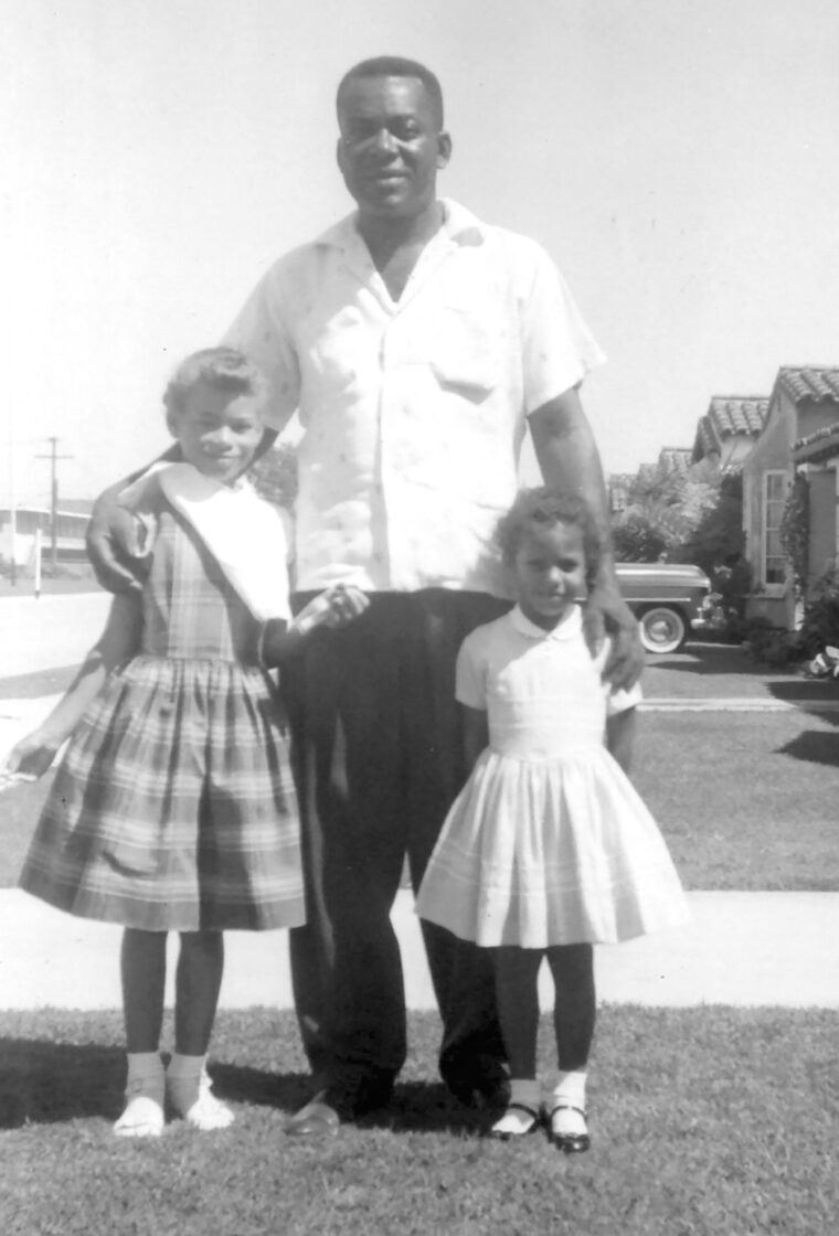 Man and two girls on front lawn