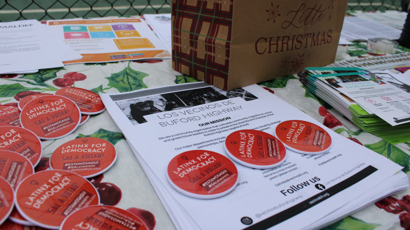 Flyers and informational materials at one of the tables at the Los Vecinos Christmas party