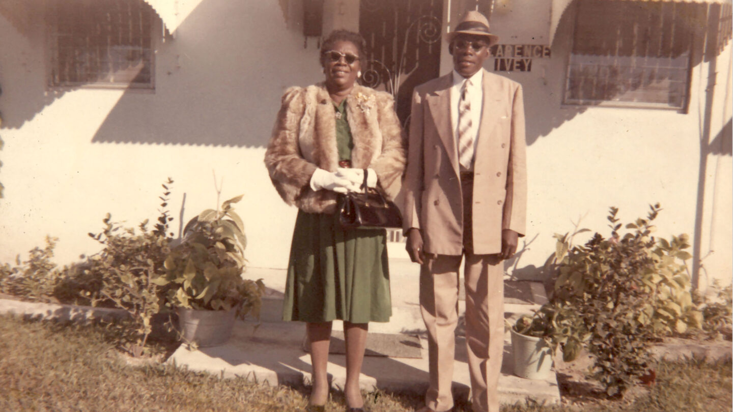 Couple in front of home with decorative screened door