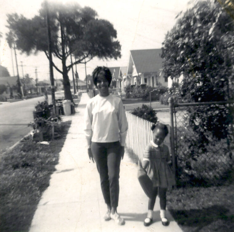 Woman with little girl standing on sidewalk