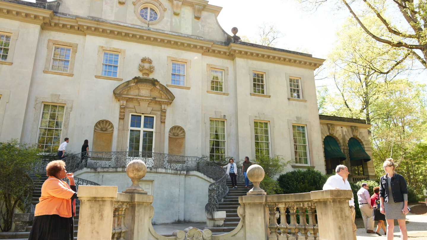 People touring the exterior of Swan House