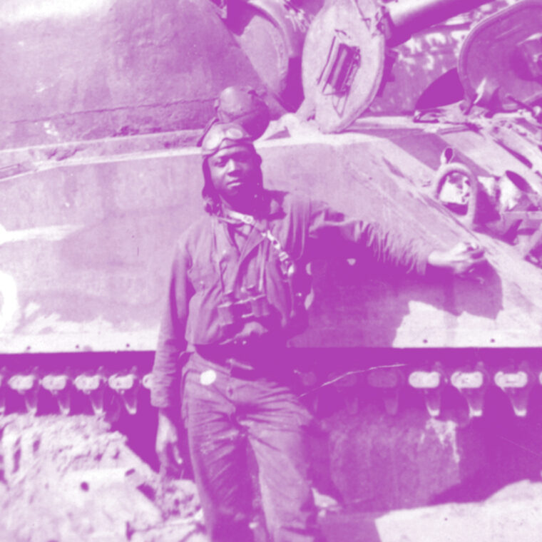 black soldier standing in front of a tank