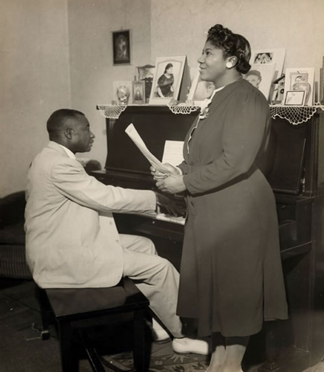 man playing piano and woman singing